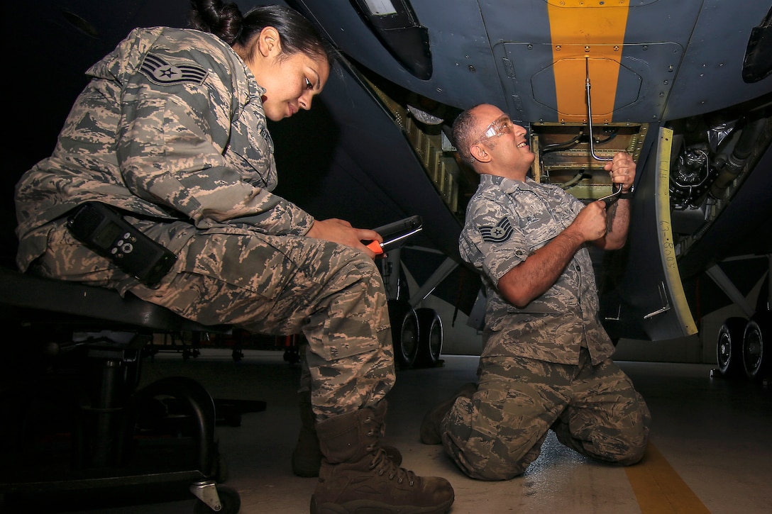 Airmen remove an antenna from a KC-135R Stratotanker.