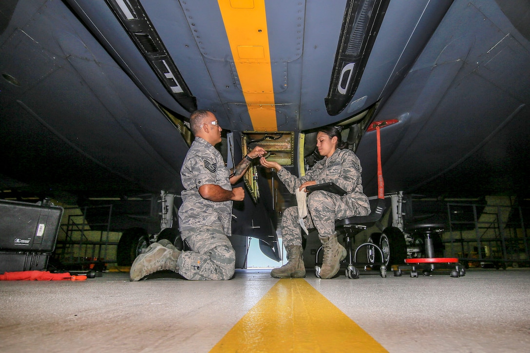 Airmen remove an antenna from a KC-135R Stratotanker.