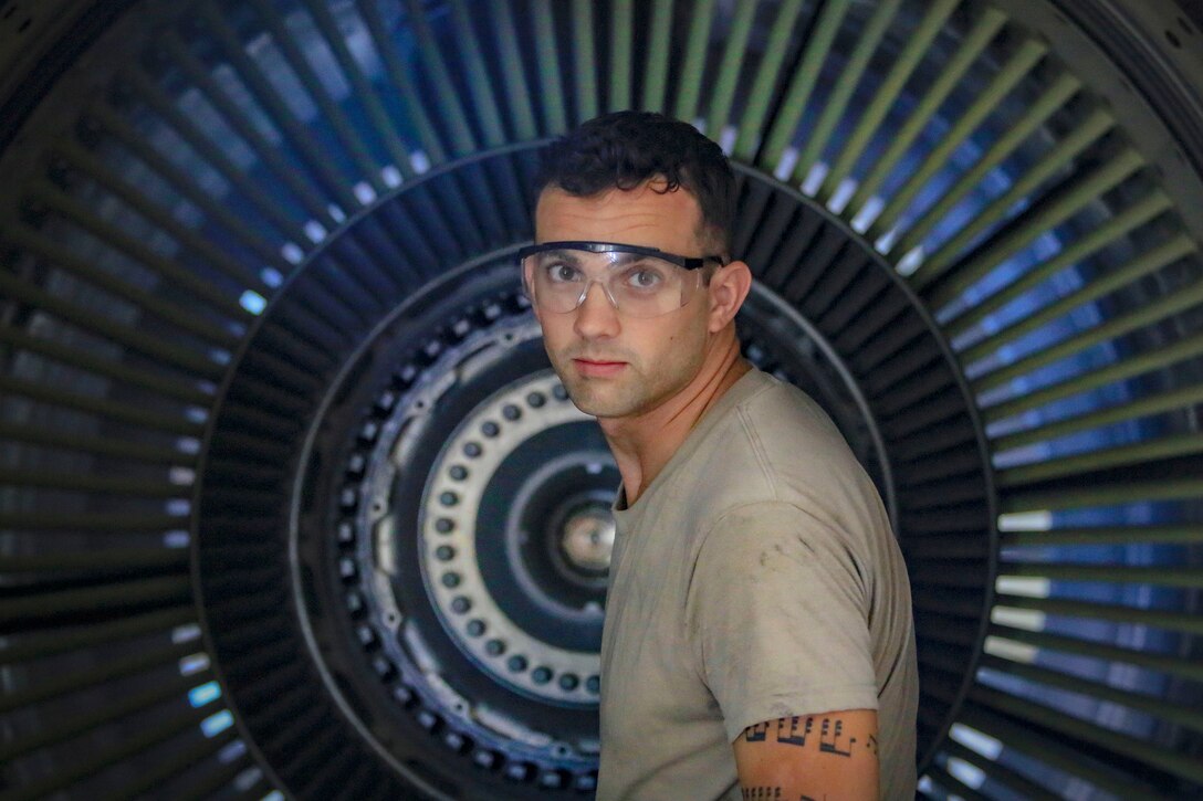 An airman removes fan blades from KC-135R Stratotanker engine for inspection.