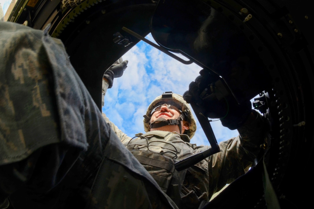 An airman provides security from the gunner’s hatch of a Humvee.