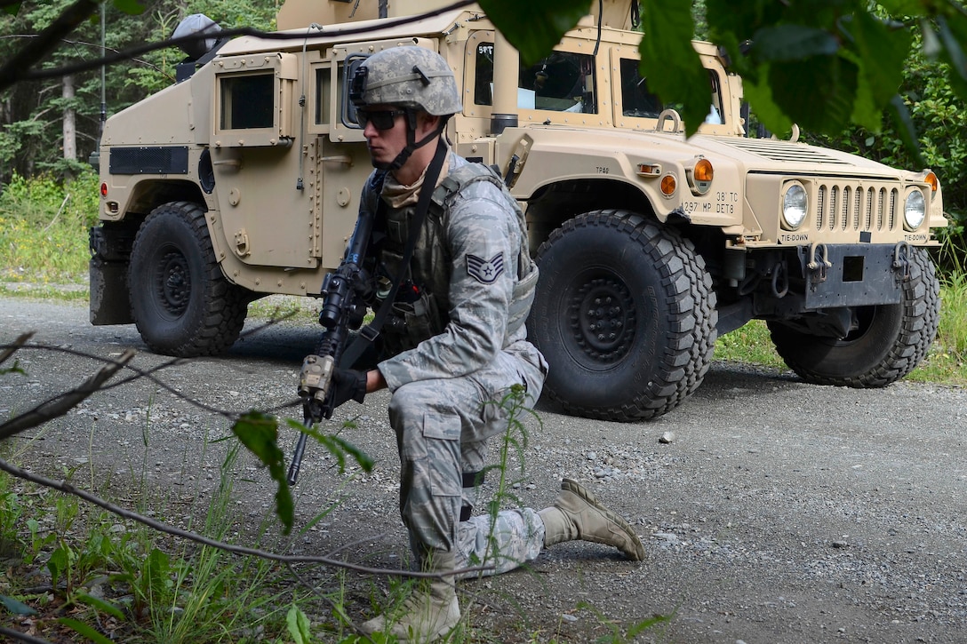 An airman screens the woody area for potential threats during a combat patrol exercise.