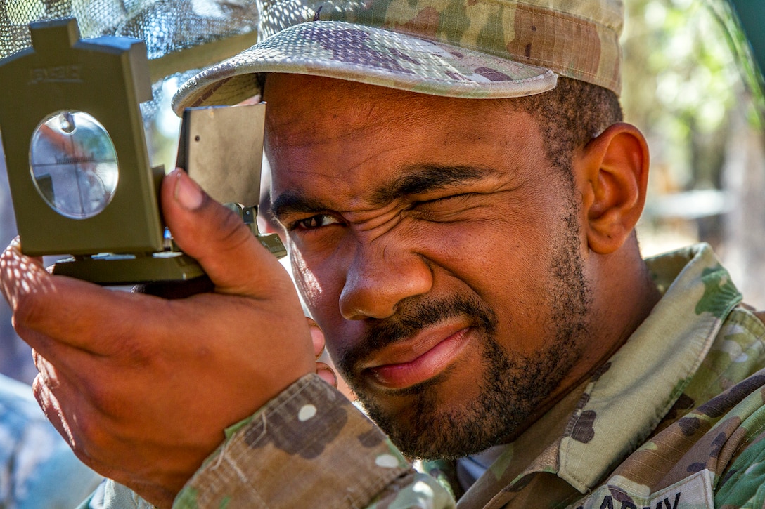 A soldier uses a land navigation tool.
