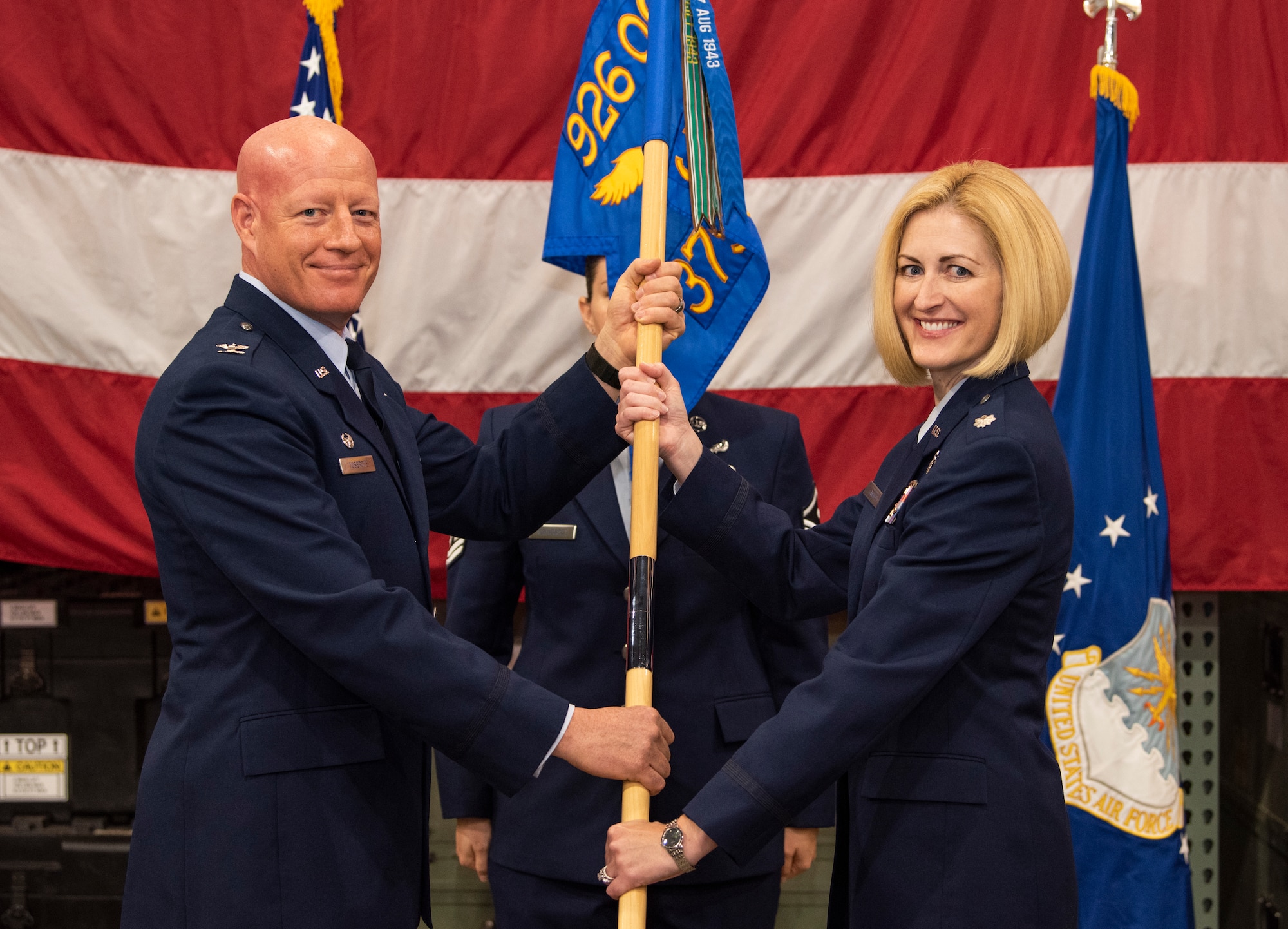 Col. Todd Tobergte, 926th Operations Group commander, passes the 379th Space Range Squadron guidon to Lt. Col. Sheila Wilds as she assumes command of the squadron during a ceremony July 14th, 2018.