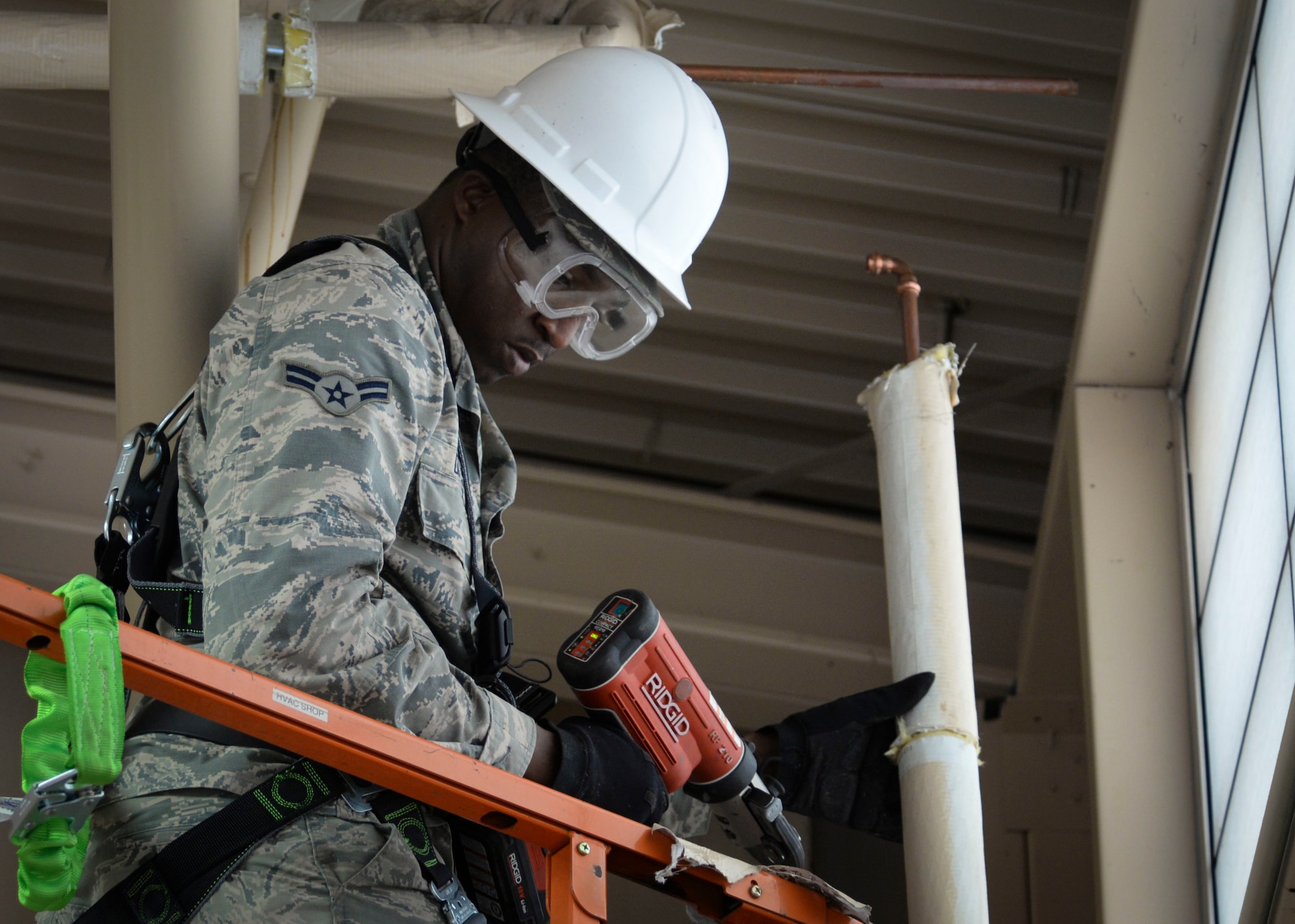 Airman 1st Class Johnathan Daniels, Heating, Ventilation, Air Conditioning/Refrigeration and Control technician assigned to the 99th Civil Engineer Squadron, repairs a broken water pipe at a 57th maintenance facility on Nellis Air Force Base. HVAC technicians are responsible for the maintenance, repair and operations of 661 facilities across Nellis, Creech Air Force Base, and the Nevada Test and Training Range. (U.S. Air Force photo by Airman Bailee A. Darbasie)