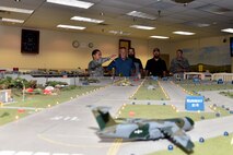 U.S. Air Force Master Sgt. Roy Campos, 312th Training Squadron advance courses chief, showcases the Norma Brown Air Force Base trainer to Louis Garland, Nathan Garland, Clayton Garland, decedents of late Chief Warrant Officer Louis F. Garland, and Tech. Sgt. Anthony Hetlage,  17th Training Wing Public Affairs broadcast journalist, in the Louis F. Garland Department of Defense Fire Academy on Goodfellow Air Force Base, Texas, July 13, 2018. The tabletop model is 12 feet by 14 feet and has everything from interchangeable buildings to lights and smoke to make the experience for the students as immersive as possible. (U.S. Air Force photo by Senior Airman Randall Moose/Released)