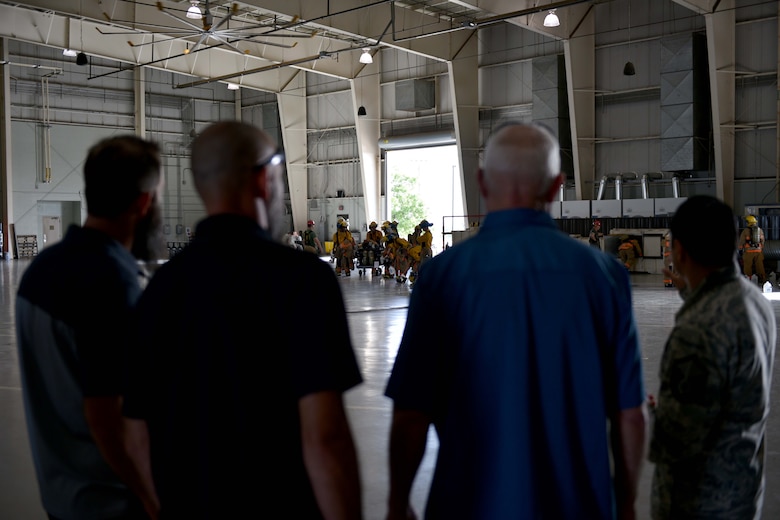 Nathan Garland, Clayton Garland, Louis Garland, decedents of late Chief Warrant Officer Louis F. Garland, and U.S. Air Force Master Sgt. Roy Campos, 312th Training Squadron advance courses chief, watch trainees in the Louis F. Garland Department of Defense Fire Academy on Goodfellow Air Force Base, Texas, July 13, 2018. The trainees train in full firefighting gear to prepare them for their careers. (U.S. Air Force photo by Senior Airman Randall Moose/Released)