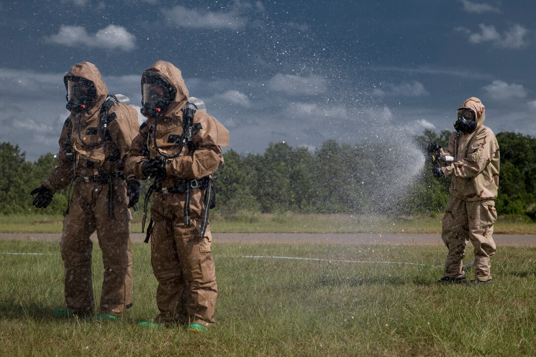 U.S. Marines with Chemical, Biological, Radiological, and Nuclear (CBRN) Platoon, Headquarters Battalion, 1st Marine Division, are sprayed down decontamination during the Concept of Real World CBRN Operations course at the Guardian Centers in Perry, Georgia, June 22, 2018.