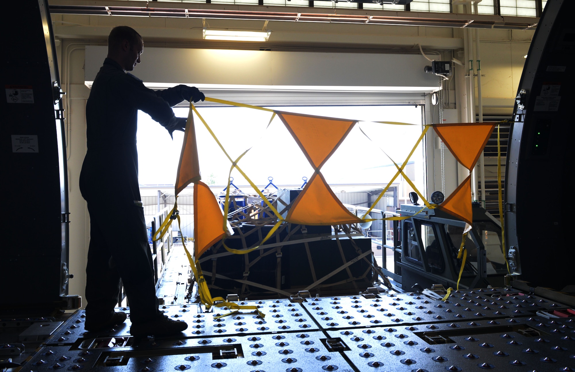 U.S. Air Force Master Sgt. Jonathan Lauterbach, NCO in charge of Readiness Flight assigned to the 56th Air Refueling Squadron, rehangs high visibility warning strap following a boom operator simulated cargo training on the Fuselage Trainer, July 10, 2018, at Altus Air Force Base, Okla.