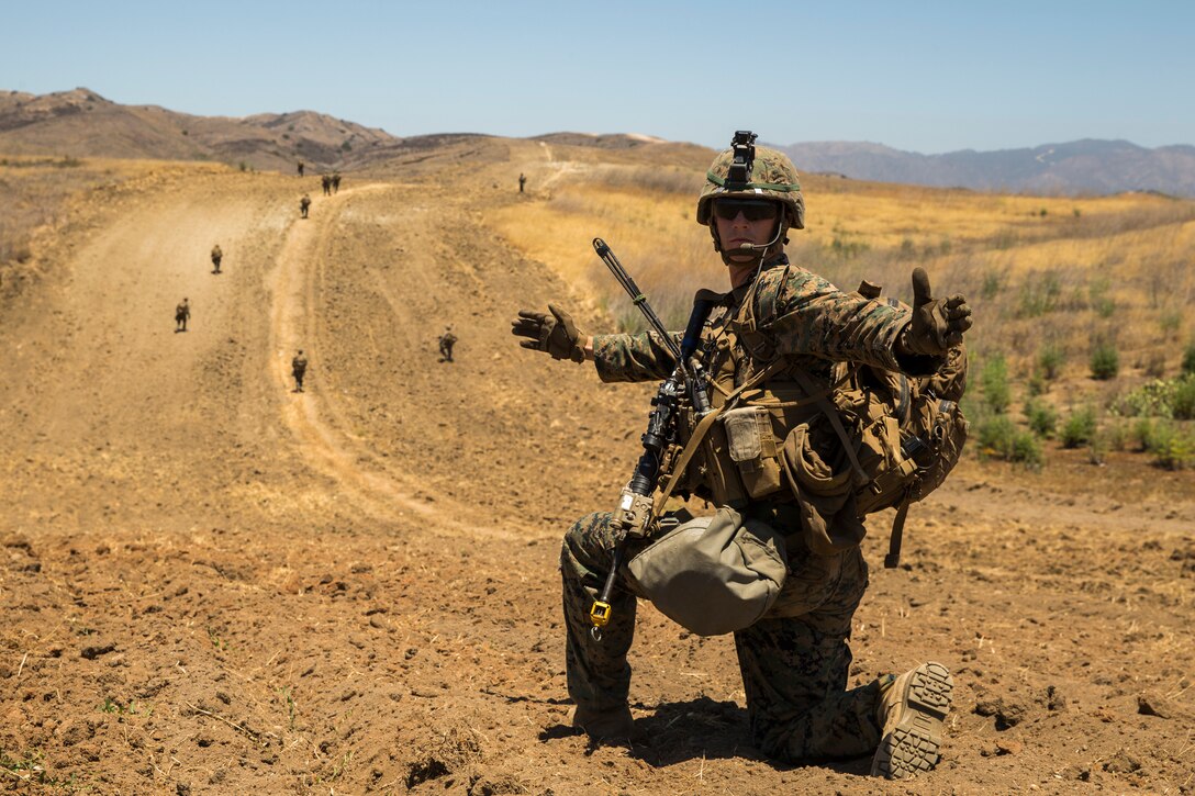 A U.S. Marine with 1st Light Armored Reconnaissance Battalion, 1st Marine Division (MARDIV), gives hand and arm signals during the Rifle Squad Competition on Marine Corps Base Camp Pendleton, Calif., June 27, 2018.