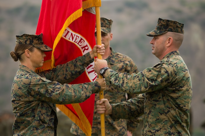 U.S. Marine Corps Lt. Col. Michelle I. Macander, left, incoming commanding officer of 1st Combat Engineer Battalion (CEB), 1st Marine Division, receives the colors from Lt. Col. Christopher M. Haar, offgoing commanding officer of 1st CEB, during a change of command ceremony at Marine Corps Base Camp Pendleton, Calif., June 22, 2018.
