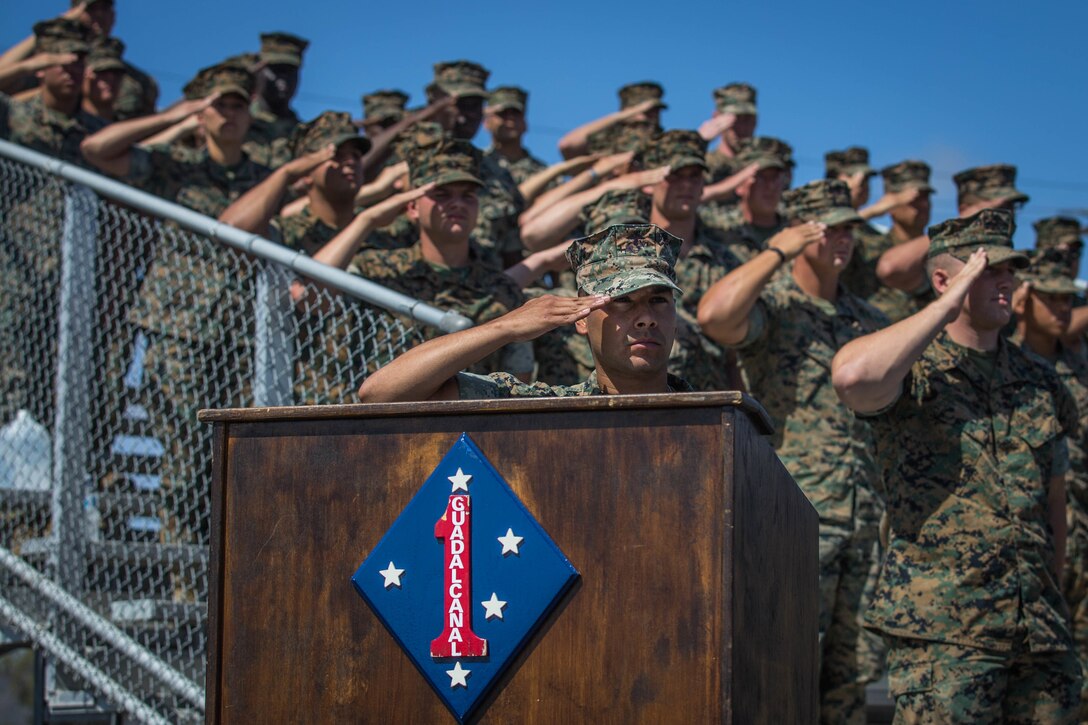 U.S. Marines with Headquarters Battalion (HQBN), 1st Marine Division (MARDIV), salute the American flag during a change of command ceremony at Marine Corps Base Camp Pendleton, Calif., June 19, 2018.