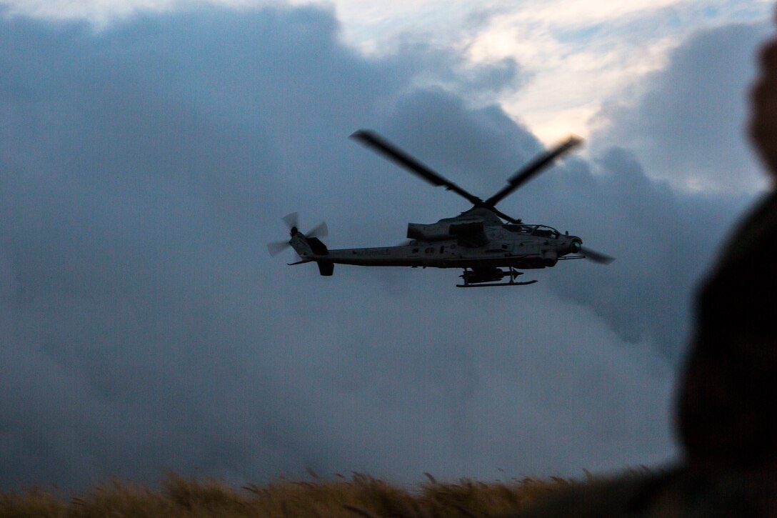 A U.S. Marine Corps AH-1Z Viper helicopter flies over the impact area during close air support as part of Rim of the Pacific (RIMPAC) exercise at Pohakuloa Training Area, Hawaii, July 14, 2018. The training involved pilots working with a joint forward air controller to coordinate the close air support of ground troops.