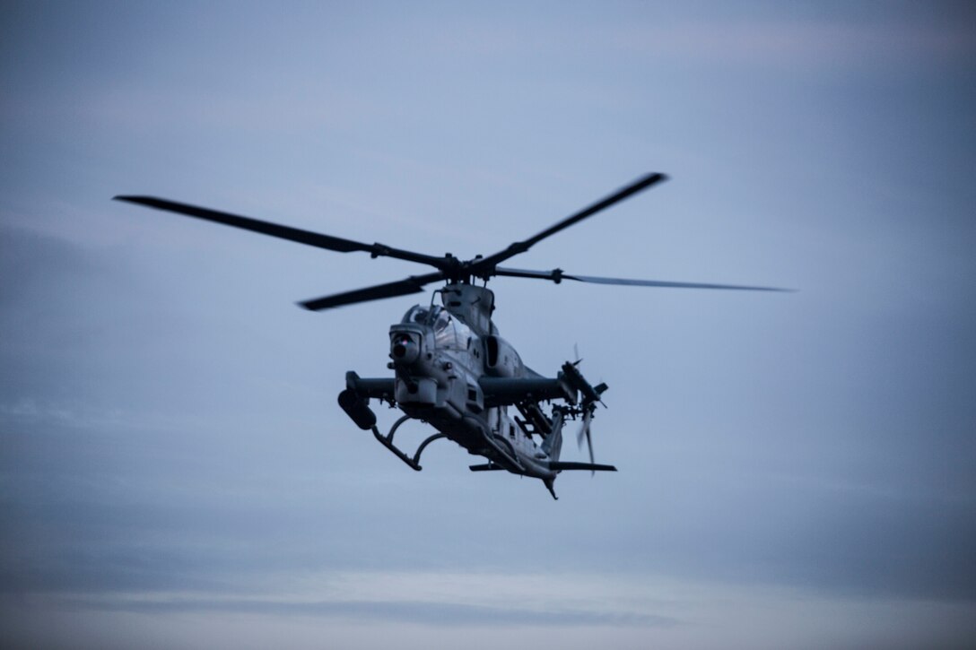 A U.S. Marine Corps AH-1Z Viper helicopter flies over an impact area during close air support as part of Rim of the Pacific (RIMPAC) exercise at Pohakuloa Training Area, Hawaii, July 14, 2018. The training involved pilots working with a joint forward air controller to coordinate the close air support of ground troops.