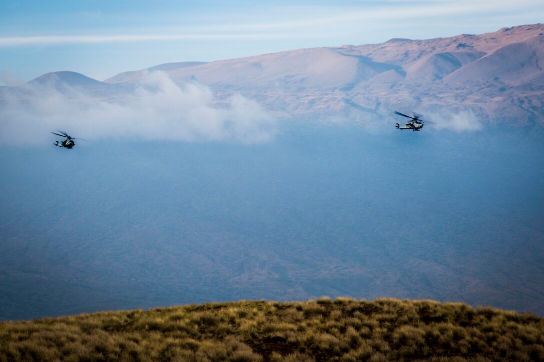 A U.S. Marine Corps UH-1Y Huey and AH-1Z Viper helicopter fly toward a target during close air support as part of Rim of the Pacific (RIMPAC) exercise at Pohakuloa Training Area, Hawaii, July 14, 2018. The training involved pilots working with a joint forward air controller to coordinate the close air support of ground troops.