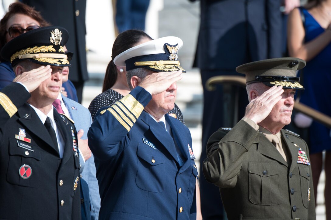 The chairman of the joint chiefs of staff and other commanders render a salute during a wreath laying ceremony.