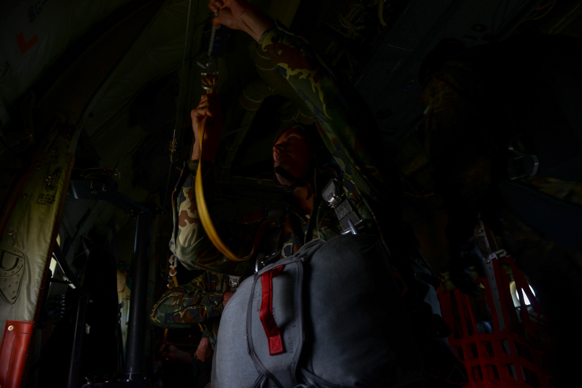 A Bulgarian jumper hooks onto a static line inside a U.S. Air Force C-130J Super Hercules aircraft over Plovdiv, Bulgaria, July 14, 2018. During Thracian Summer 2018, U.S. and Bulgarian forces trained both static-line jumps and free falls. (U.S. Air Force photo by Staff Sgt. Jimmie D. Pike)