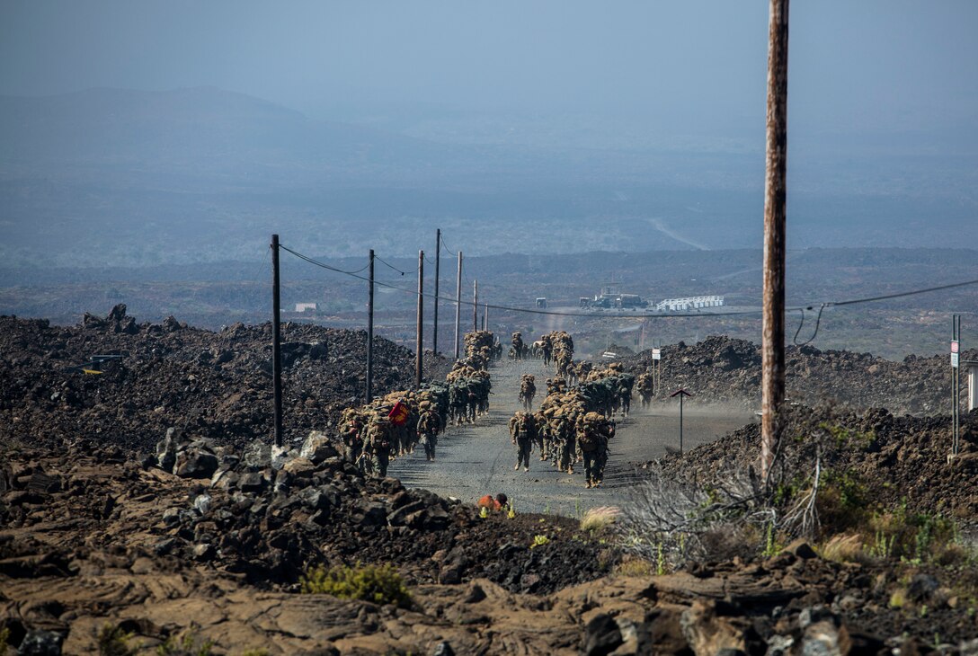U.S. Marines hike to a firing range during Rim of the Pacific (RIMPAC) exercise at Pohakuloa Training Area, Hawaii, July 15, 2018. RIMPAC provides high-value training for task-organized, highly capable Marine Air-Ground Task Force and enhances the critical crisis response capability of U.S. Marines in the Pacific.
