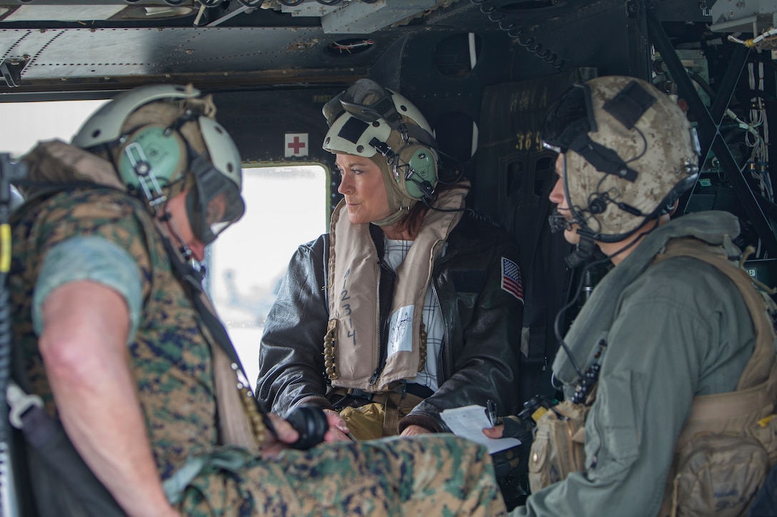 The Honorable Phyllis L. Bayer, center, Assistant Secretary of the Navy – Energy, Installations and Environment, Major General Vincent A. Coglianese, left, commander, Marine Corps Installations Command, and Sergeant Dallas Hodges, crew chief, Marine Light Attack Helicopter Squadron 369, 3rd Marine Aircraft Wing, prepare for take off in a UH-1Y Venom Helicopter during her visit to Marine Corps Base Camp Pendleton, California, July 16, 2018.