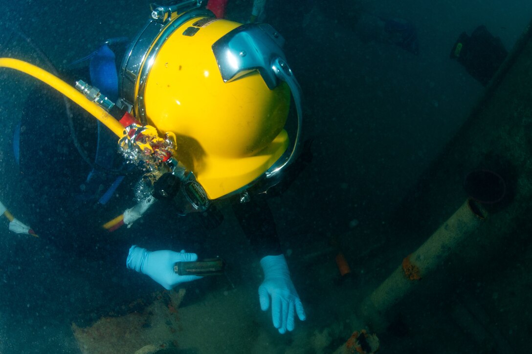 A sailor finishes preparing a worksite for training during underwater welding operation.