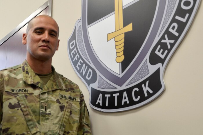 A soldier poses next to seal.