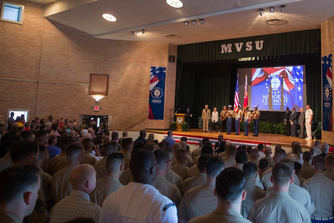 Loved ones, community members and distinguished visitors stand for the national anthem in the Mississippi Valley State University auditorium to honor the sacrifice of the fallen passengers and crew of Yanky 72, during the Memorial Ceremony, July 14, 2018. The Yanky 72 Memorial Ceremony was held to remember and honor the ultimate sacrifices made by the fallen Marines and Sailor of VMGR-452 and Marine Corps Special Operations Command. (U.S. Marine Corps photo by Lance Cpl. Samantha Schwoch/released)
