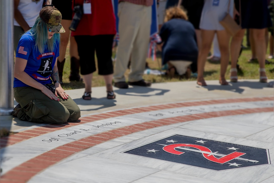 Jessica Jenson, reacts to seeing the name of her late husband, Sgt. Chad E. Jenson, on a marble monument honoring the fallen Marines and sailor, lost in a 2017 plane crash near Itta Bena, Miss., Jul 14, 2018. More than 200 relatives and friends of the 16 people who died aboard the flight with the call sign Yanky 72, joined by countless county residents and military supporters at the ceremonies on campus of Mississippi Valley State University and across the street. (U.S. Marine Corps photo by Lance Cpl. Samantha Schwoch/released)