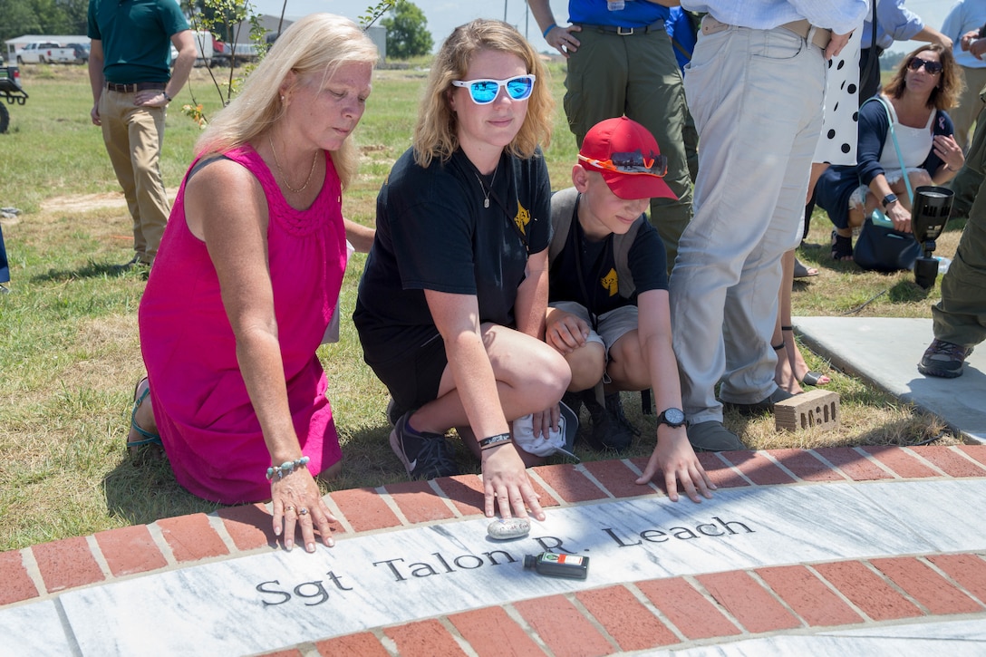 Family members pose next to the name of late Marine Sgt. Talon R. Leach, on a marble monument honoring the fallen Marines and sailor, lost in a 2017 plane crash near Itta Bena, Miss., Jul 14, 2018. More than 200 relatives and friends of the 16 people who died aboard the flight with the call sign Yanky 72, joined by countless county residents and military supporters at the ceremonies on campus of Mississippi Valley State University and across the street. (U.S. Marine Corps photo by Lance Cpl. Samantha Schwoch/released)