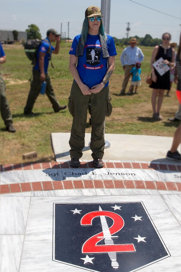 Jessica Jenson, poses next to the name of her late husband, Sgt. Chad E. Jenson, on a marble monument honoring the fallen Marines and sailor, lost in a 2017 plane crash near Itta Bena, Miss., Jul 14, 2018. More than 200 relatives and friends of the 16 people who died aboard the flight with the call sign Yanky 72, joined by countless county residents and military supporters at the ceremonies on campus of Mississippi Valley State University and across the street. (U.S. Marine Corps photo by Lance Cpl. Samantha Schwoch/released)