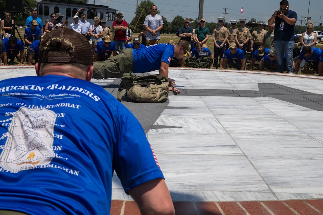 The Marine Raider Memorial March participants do a set of pushups around the Memorial Marker, after the dedication ceremony, to say a prayer before beginning the 900 mile ruck march from Greenwood, Miss. To Camp Lejeune, N.C., on July 14, 2018. The group of 30 former comrades and widows of members of Marine 2nd Raider Battalion will have rotating teams that will be on the road around the clock through July 27, carrying dirt from the crash site of the fallen Marines and Sailor, back to the home station of Camp Lejeune, N.C. (U.S. Marine Corps photo by Lance Cpl. Samantha Schwoch/released)