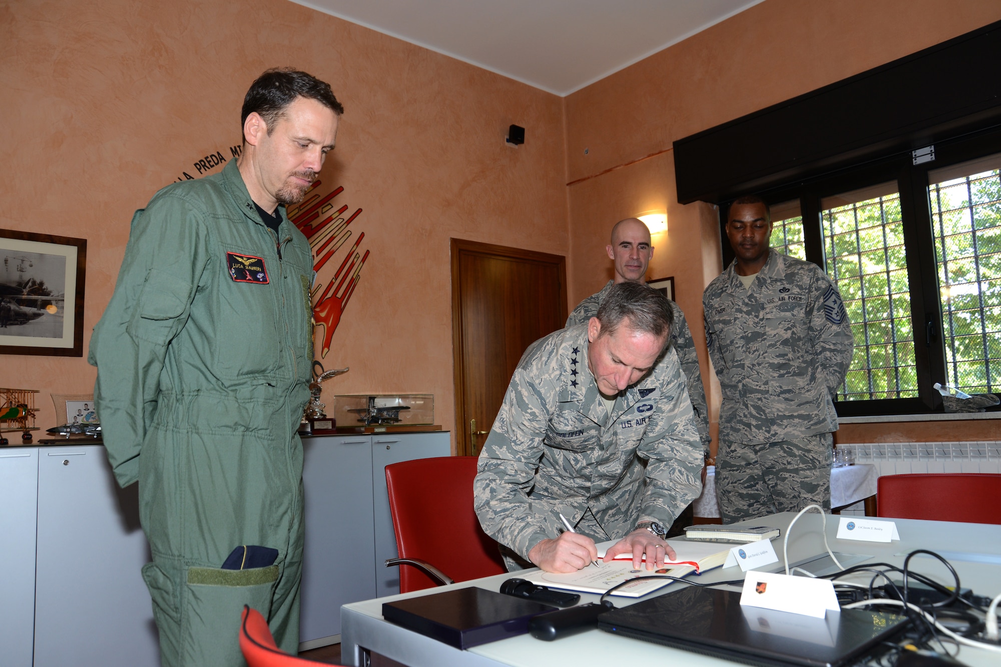 Italian Air Force Col. Luca Maineri, commander of NATO’s 6th Stormo Wing, observes as U.S. Chief of Staff of the Air Force Gen. David L. Goldfein signs a guest of honor book during his visit to Ghedi Air Base, Italy, July 9, 2018. There, he received a base tour that included the 704th Munitions Support Squadron, a geographically separated unit assigned to the 52nd Fighter Wing at Spangdahlem AB, Germany. (Courtesy photo)