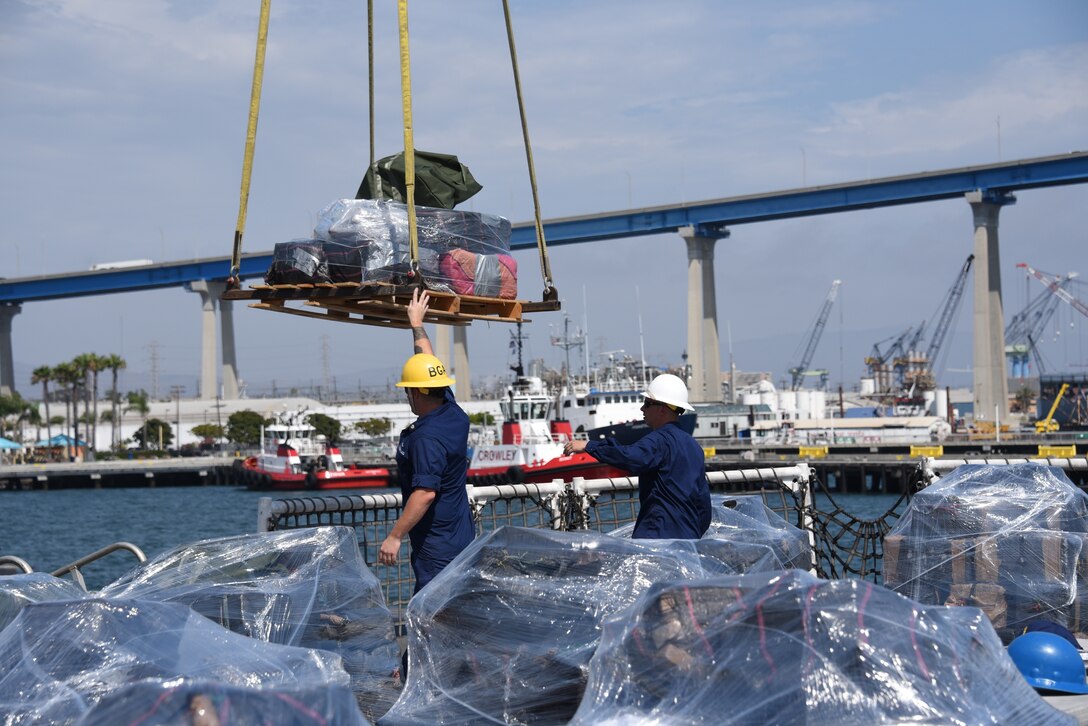 Crew members from the Coast Guard Cutter Steadfast send off a pallet of seized cocaine