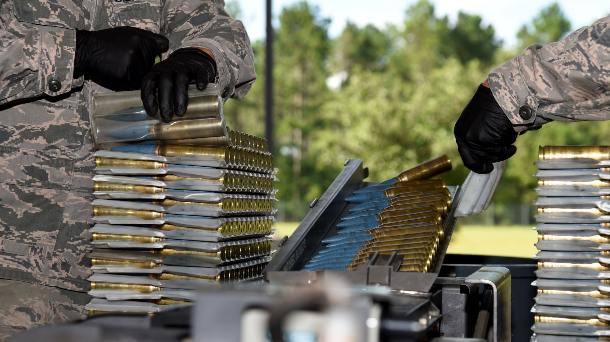 U.S. Air Force Senior Airmen Zachary Manzella, left, and Alexander Keck-Leedy, 20th Equipment Maintenance Squadron (EMS) conventional maintenance crew chiefs, load 20 mm rounds into a universal ammunition loading (UAL) system at Shaw Air Force Base, S.C., July 10, 2018.