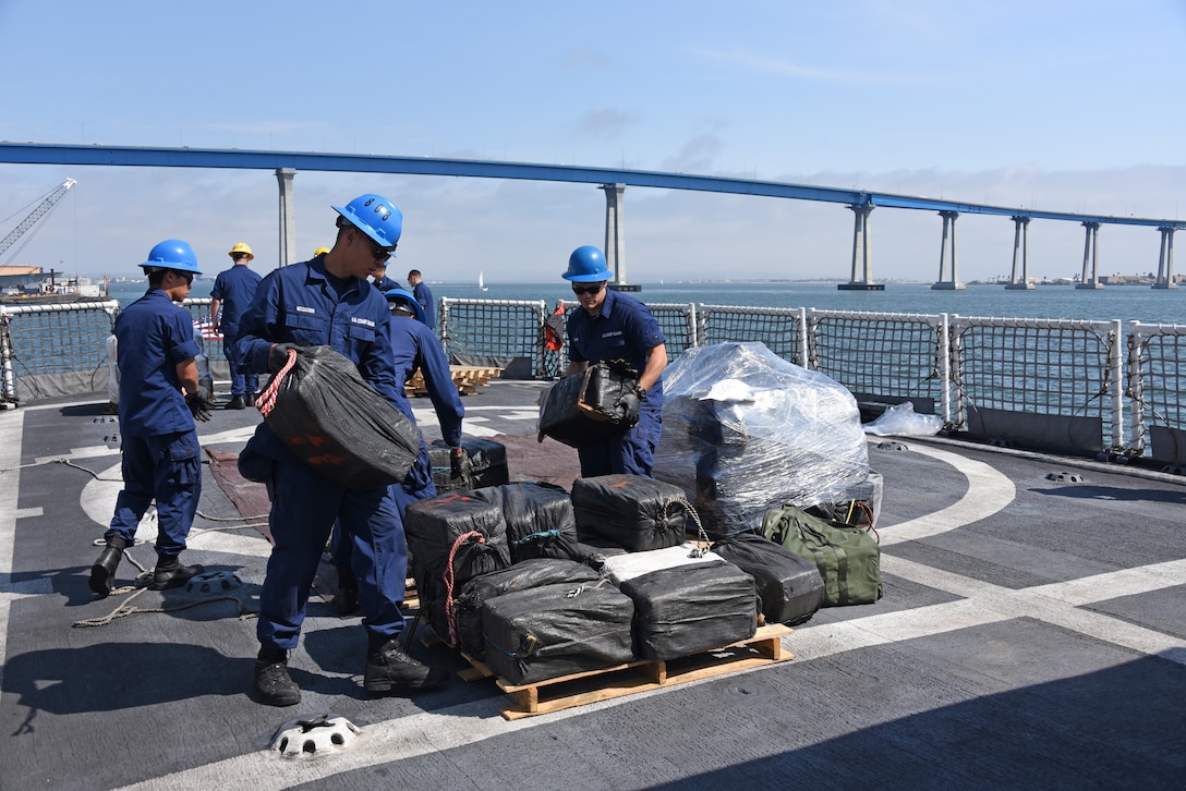 Crew members from the Coast Guard Cutter Steadfast load a pallet of seized cocaine