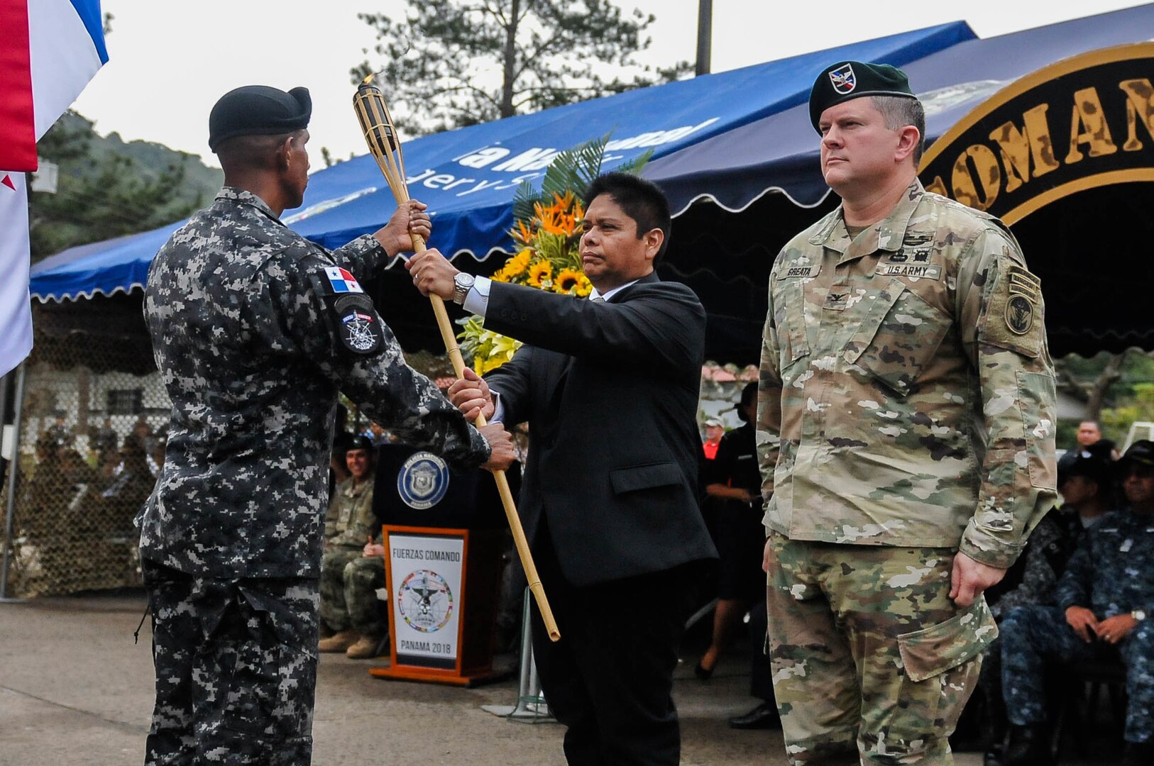 Minister Alexis Bethancourt Yau, minister of public security, and U.S. Army Col. Brian Greata, deputy commanding officer of Special Operations Command South accept a torch from the Panamanian Comandos.