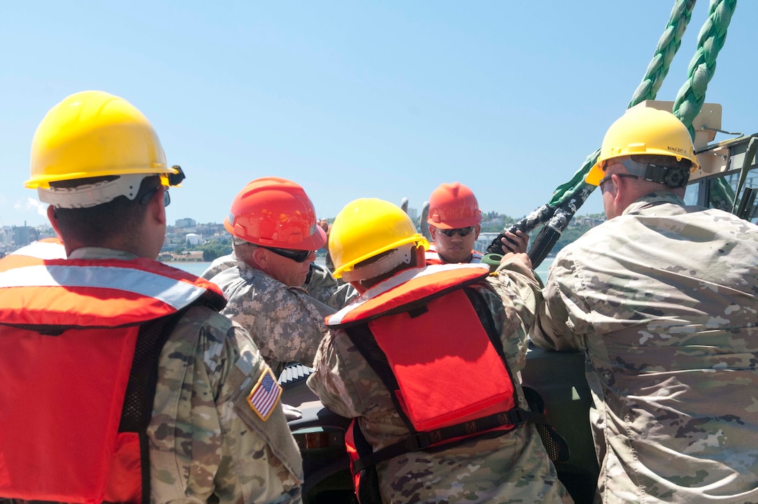 Army watercraft operators prepare to load vehicles.