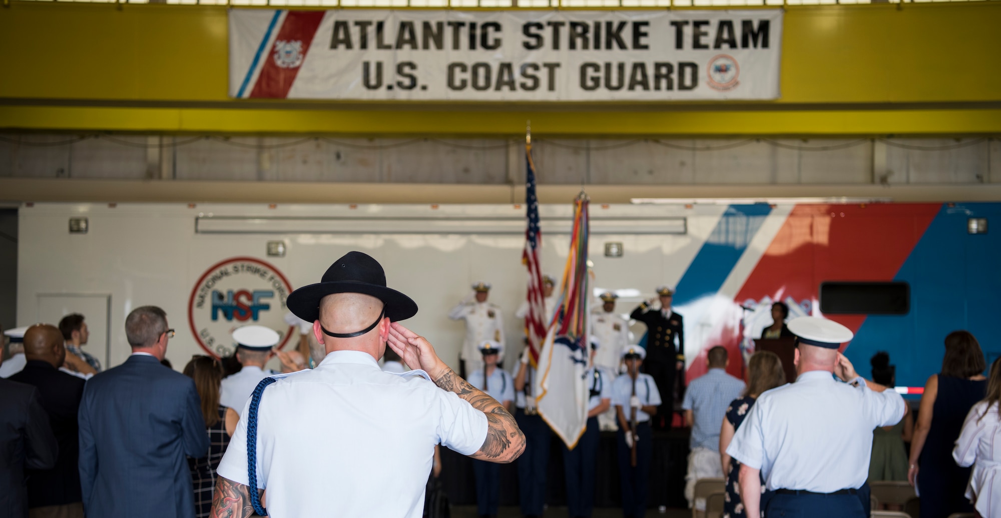 Members of the Joint Base McGuire-Dix-Lakehurst community pay their respect to the American flag during the National Anthem at the U.S. Coast Guard Atlantic Strike Team change of command ceremony on Joint Base MDL, N.J., July 12, 2018. Recognized by law in 1931, all members of the armed forces and veterans salute during the National Anthem while civilians place their hand over the heart. (U.S. Air Force photo by Airman Ariel Owings)