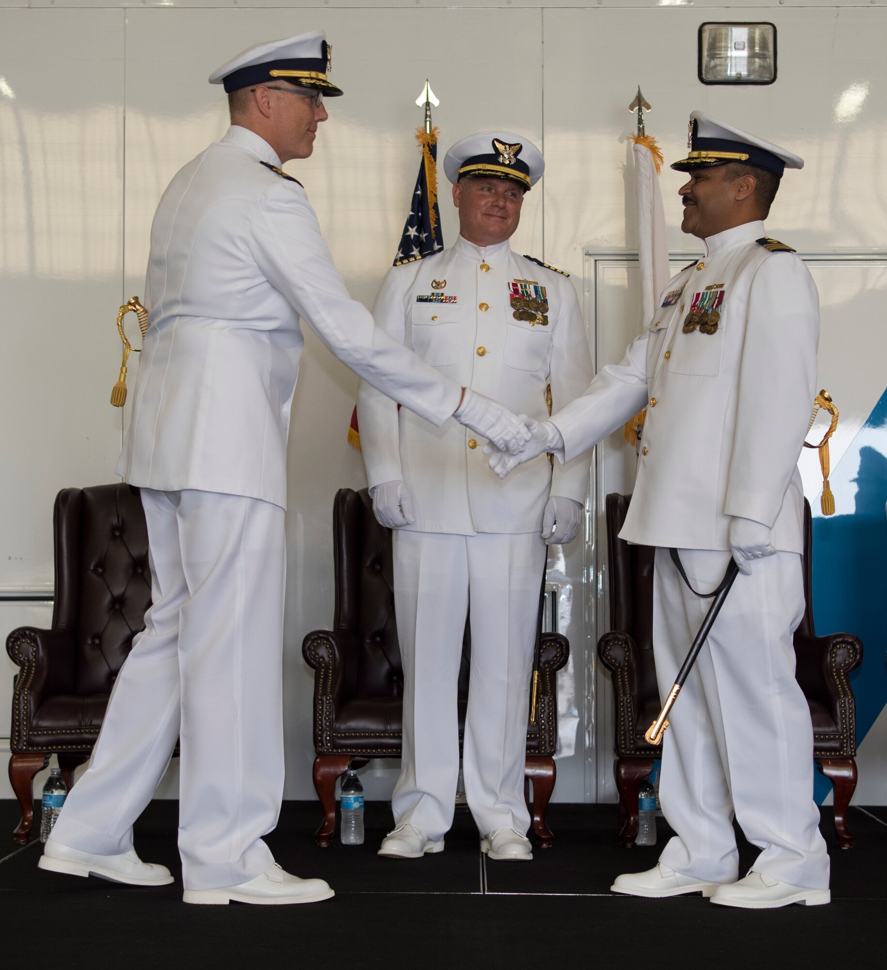 Cmdr. Tedd Hutley, outgoing commander of the U.S. Coast Guard Atlantic Strike Team, shakes hands with Cmdr. Raymond Negron, incoming commanding officer of the Atlantic Strike Team, during the change of command ceremony on Joint Base McGuire-Dix-Lakehurst, N.J., July 12, 2018. Hutley will be heading to Coast Guard Headquarters to be the National Strike Force and CBRN capabilities division chief. (U.S. Air Force photo by Airman Ariel Owings)