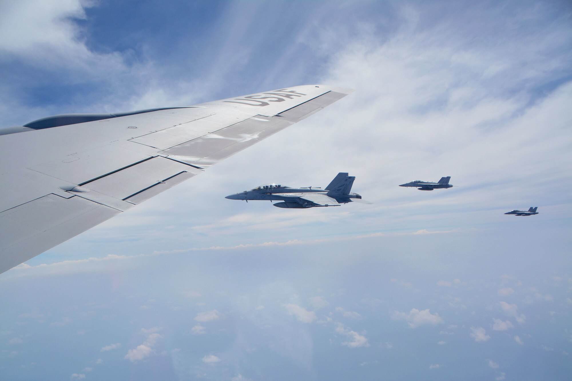 Three U.S. Navy F/A-18 Super Hornets from Carrier Air Wing Two, assigned to the aircraft carrier USS Carl Vinson (CVN 70), fly over the Pacific Ocean alongside a 507th Air Refueling Wing KC-135R Stratotanker from Tinker Air Force Base, Oklahoma, while participating in the Rim of the Pacific (RIMPAC) exercise, July 10. Twenty-five nations, 46 ships, five submarines, and about 200 aircraft and 25,000 personnel are participating in RIMPAC from June 27 to Aug. 2 in and around the Hawaiian Islands and Southern California. The world’s largest international maritime exercise, RIMPAC provides a unique training opportunity while fostering and sustaining cooperative relationships among participants critical to ensuring the safety of sea lanes and security of the world’s oceans. RIMPAC 2018 is the 26th exercise in the series that began in 1971. (U.S. Air Force photo by Tech. Sgt. Samantha Mathison)