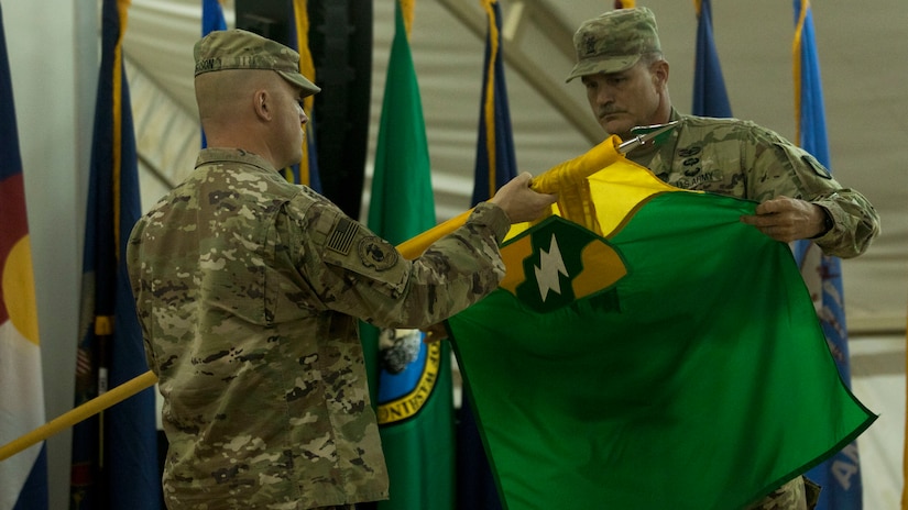 U.S. Army Col. Robert Ferguson, commander of the 155th Armored Brigade Combat Team, Mississippi Army National Guard, and Command Sgt. Maj. John Beasley, the command sergeant major of the 155th ABCT, unfurl the unit colors as they assume authority from the 2nd Brigade, 1st Armored Division, at Camp Buehring, Kuwait, July 15, 2018. Ferguson stated the 155th ABCT was capable and ready to answer any mission assigned to the unit.