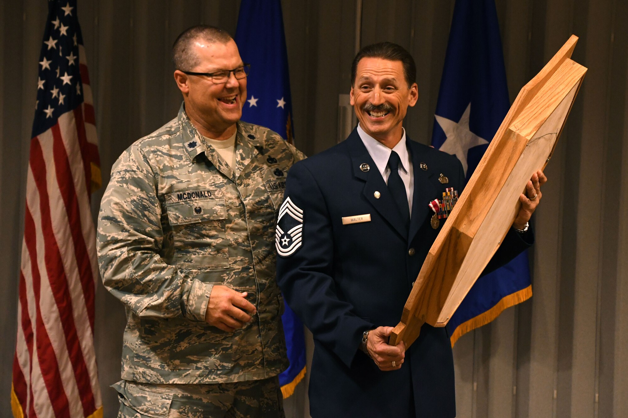 Chief Master Sgt. Robert L. Walter, 94th Force Support Squadron superintendent, smiles upon receiving a shadow box during his retirement ceremony held here July 14, 2018. Walter retired after 36 years of service in the active-duty Air Force, Air National Guard and, most recently, the Air Force Reserve. (U.S. Air Force photo/Senior Airman Josh Kincaid)
