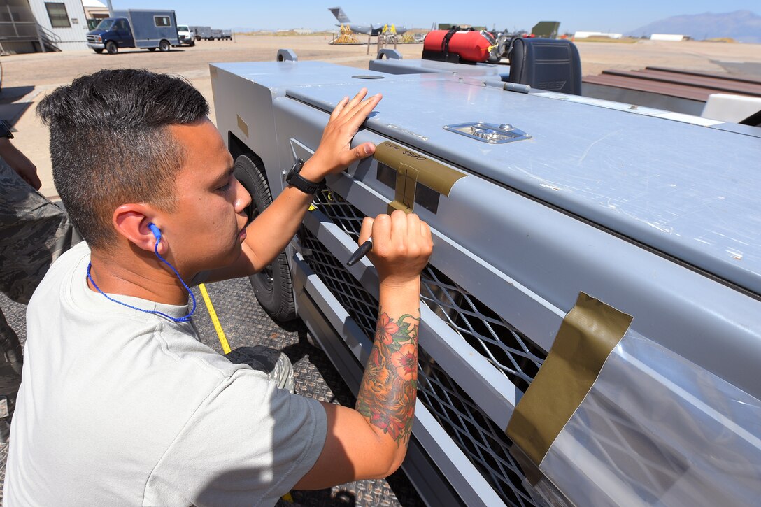 Senior Airman Franklin Herrera-Saucdo, 388th Maintenance Squadron, marks the center of tractor during an exercise July 13, 2018, at Hill Air Force Base Utah. (U.S. Air Force photo by Todd Cromar)