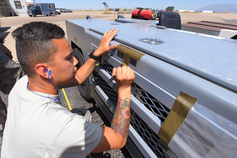 Senior Airman Franklin Herrera-Saucdo, 388th Maintenance Squadron, marks the center of tractor during an exercise July 13, 2018, at Hill Air Force Base Utah. (U.S. Air Force photo by Todd Cromar)