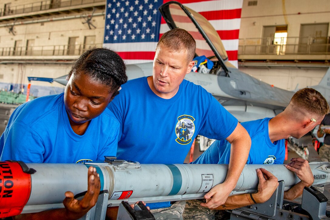 Airmen lift a missile during a competition.