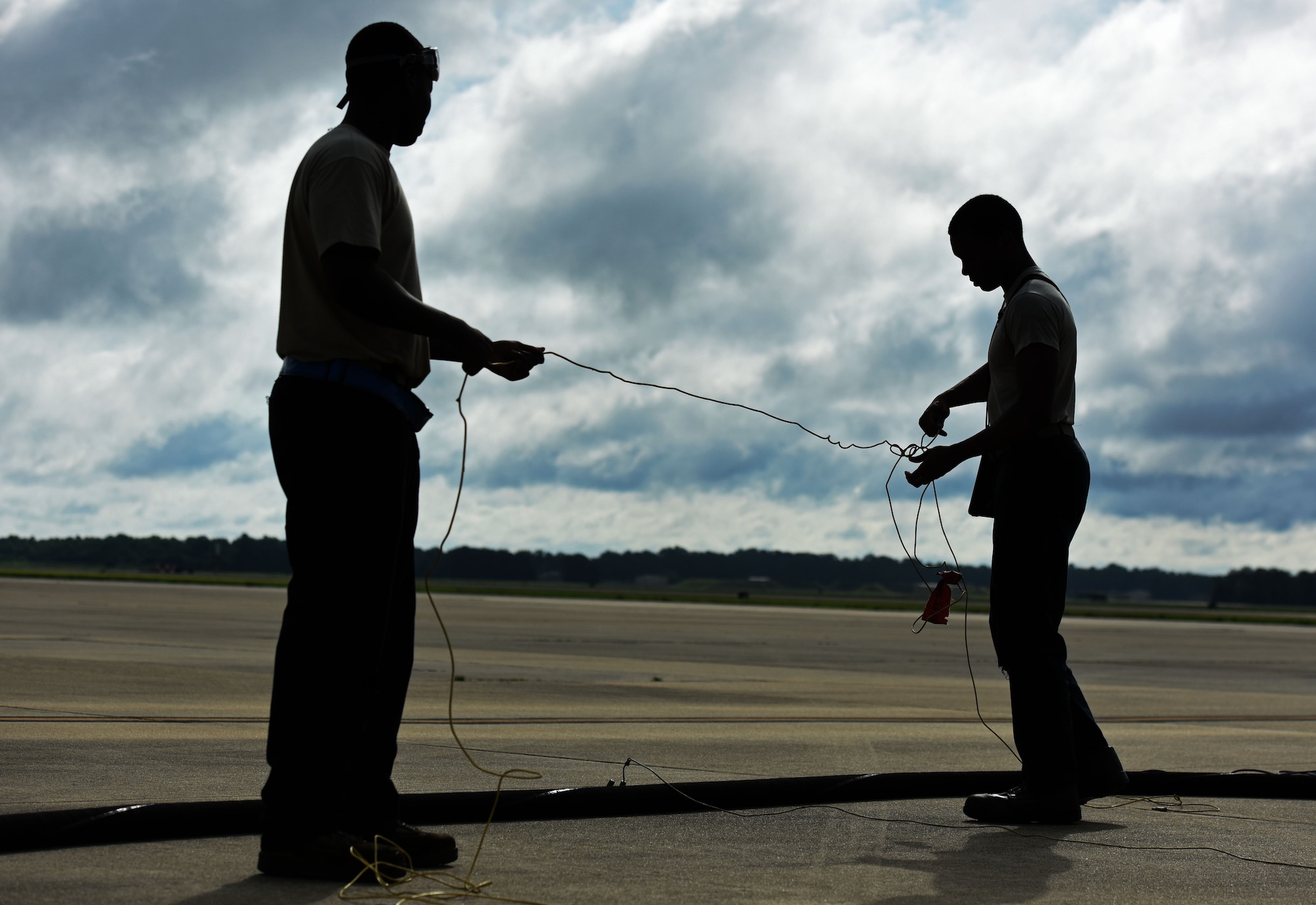 U.S. Air Force Airman 1st Class Joey Albright, left, and Staff Sgt. Jameson Holmes, 20th Aircraft Maintenance Squadron (AMXS) tactical aircraft maintainers, work together to untangle a cable at Shaw Air Force Base, S.C., June 26, 2018.