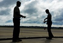 U.S. Air Force Airman 1st Class Joey Albright, left, and Staff Sgt. Jameson Holmes, 20th Aircraft Maintenance Squadron (AMXS) tactical aircraft maintainers, work together to untangle a cable at Shaw Air Force Base, S.C., June 26, 2018.