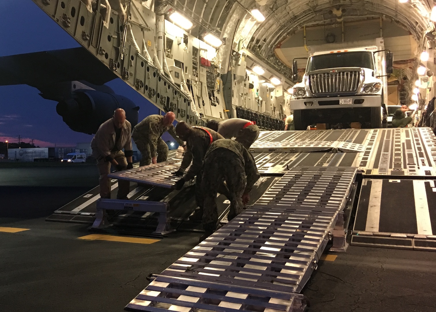 Members of Joint Task Force Civil Support (JTF-CS) lay down ramps in preparation of loading vehicles onto a Boeing C-17 Globemaster III during a no-notice Deployment Readiness Exercise (DRE). The purpose of the DRE was to test both commands ability to rapidly deploy during an incident. When directed, JTF-CS is ready to respond in 24 hours to provide command and control of 5,200 federal military forces located at more than 36 locations throughout the nation acting in support of civil authority response operations to save lives, prevent further injury, and provide critical support to enable community recover. (Official DoD photo by Air Force Lt. Col. Karen Roganov/released)