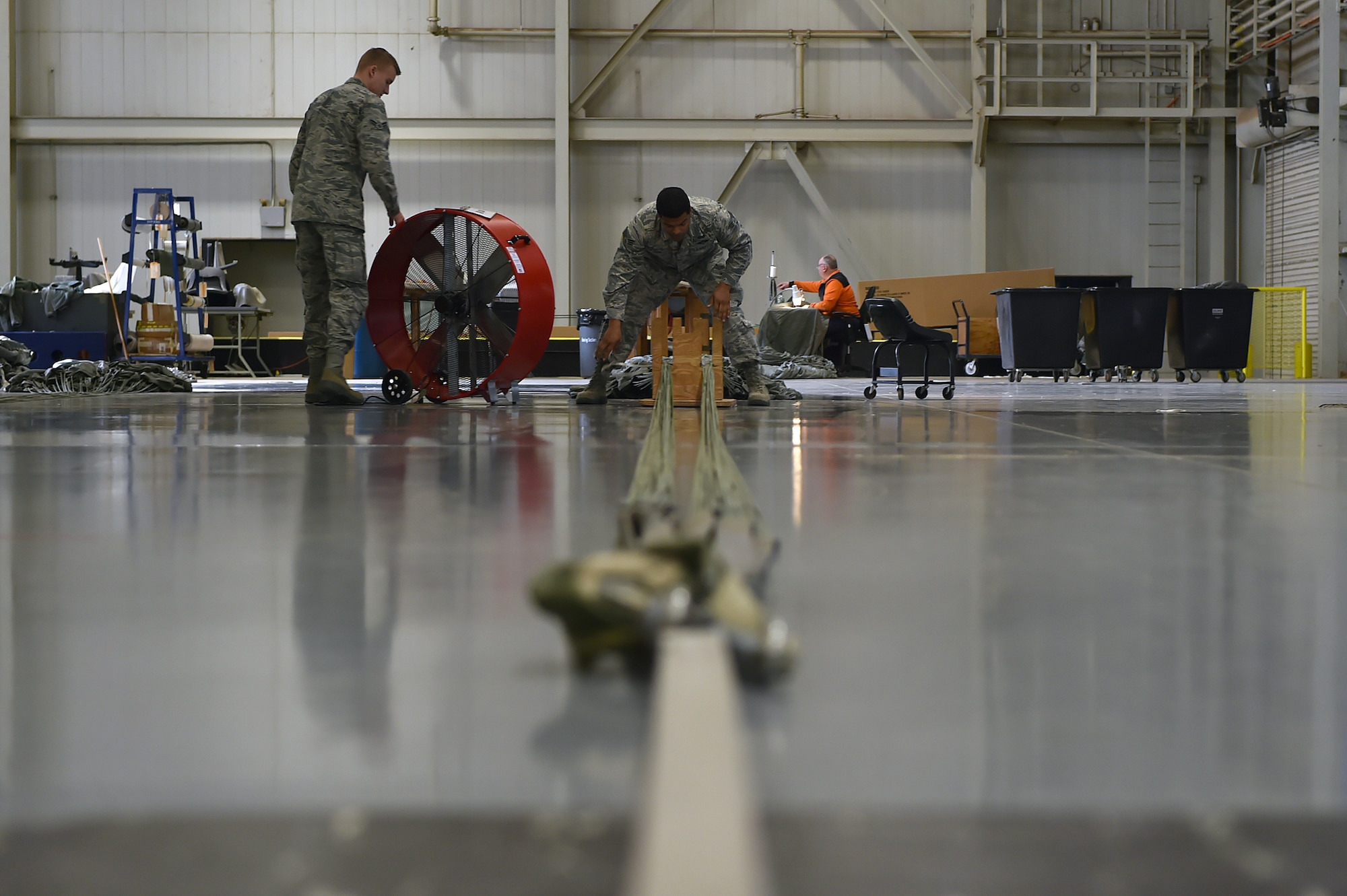 U.S. Air Force Senior Airman Allen Cook, an air freight specialist assigned to the 97th Logistics Readiness Squadron, separates cargo parachute strings to inspect it for damages, Feb. 12, 2018, at Altus Air Force Base, Okla.