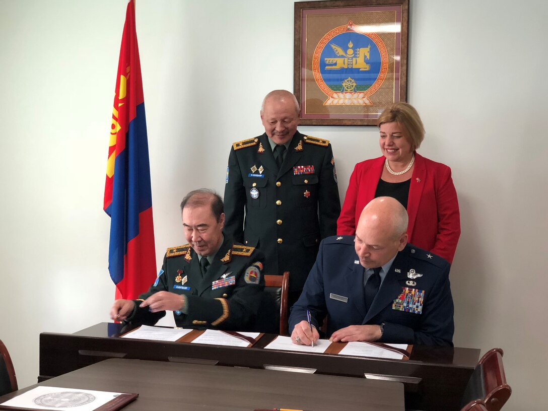 Mongolian air force Brig. Gen. Enkhbayar, Mongolian air force command commander, back left, and Heidi H. Grant, U.S. deputy Under Secretary of the Air Force, international affairs, back right, observe Mongolian air force Brig. Gen. Batbayar, Mongolian air force command deputy commander, front left, and U.S. Air Force Brig. Gen. Daniel Yenchesky, the Air National Guard assistant to the commander of 11th Air Force, sign the terms of reference for establishing Airmen-to-Airmen talks (A2A) at Ulannbaatar, Mongolia, May 17, 2018.