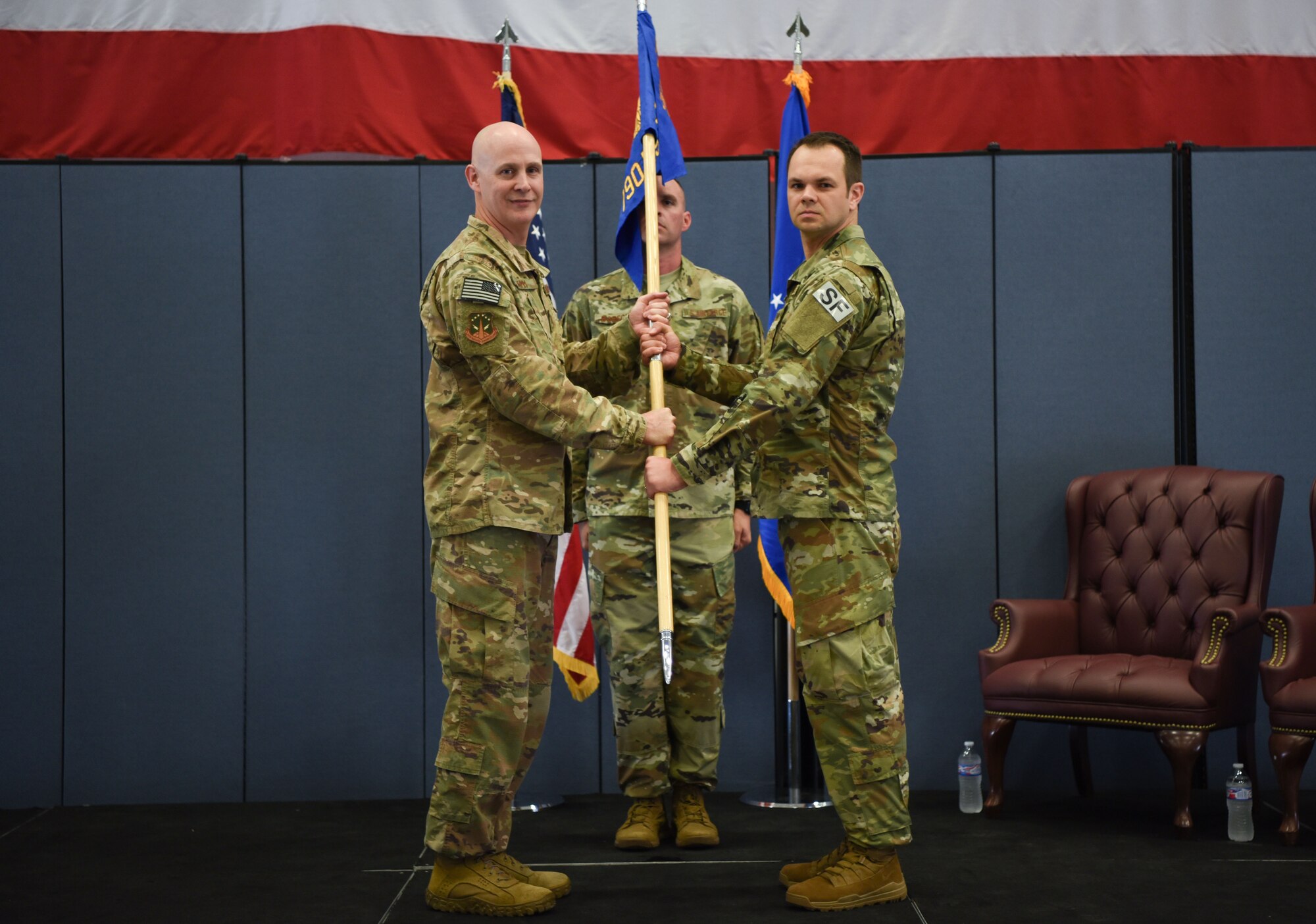 Colonel John Grimm, 90th Security Forces Group commander, passes the guidon to Maj. Jaroslaw Zrodlowski, 790th Missile Security Forces Squadron commander, during the 790th MSFS assumption of command ceremony at F.E. Warren Air Force Base, Wyo., July 17, 2018. The ceremony signified the assumption of command and formal transfer of authority to Zrodlowski. (U.S. Air Force photo by Airman 1st Class Abbigayle Wagner)