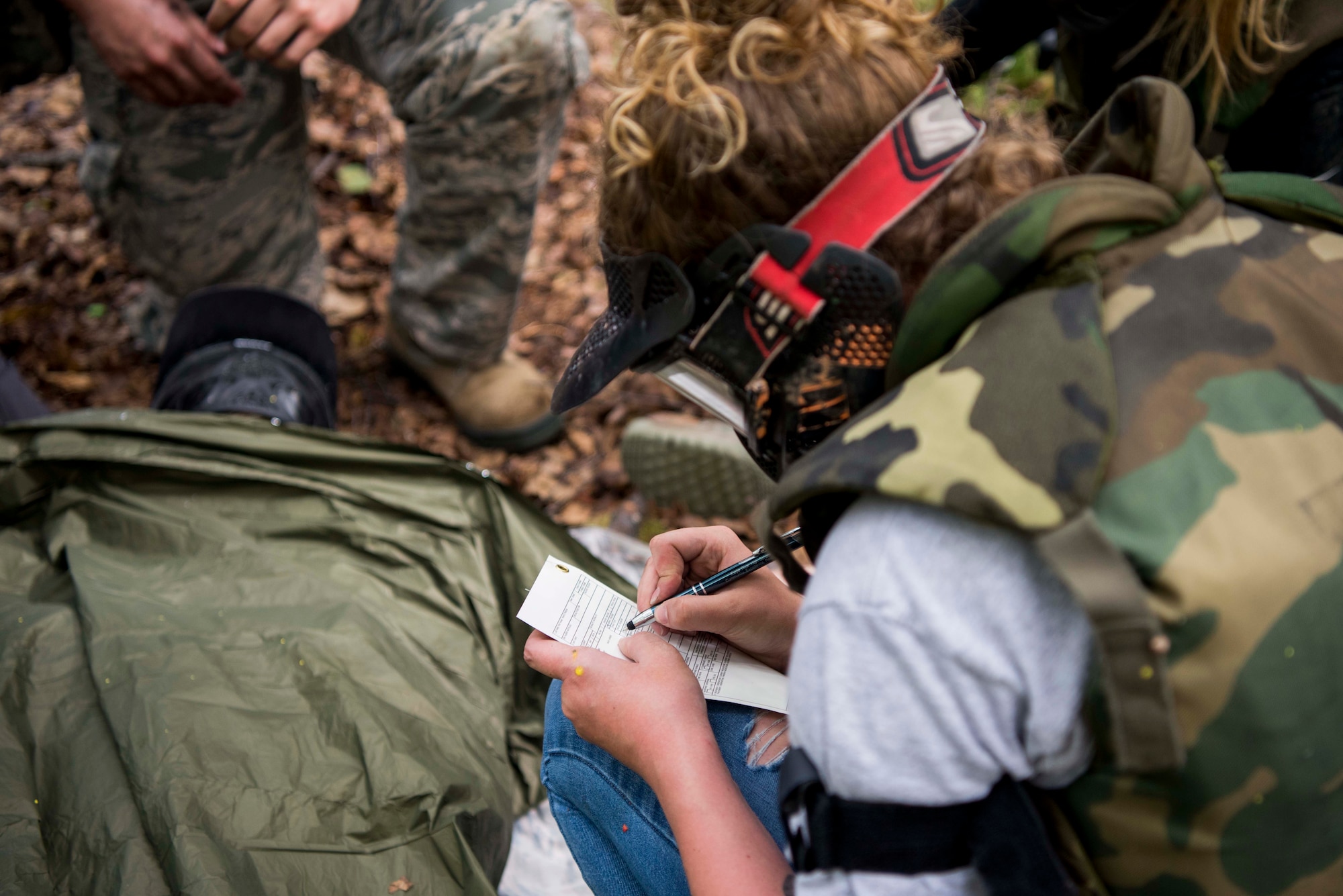 U.S. Air Force 2nd Lt. Shelby Landfair, registered nurse assigned to the 673d Inpatient Operations Squadron, fills out a DD form 1380, Tactical Combat Casualty Care medical card, during the practical application of the TCCC course at the Warrior Extreme Paintball course at Joint Base Elmendorf-Richardson, Alaska, July 13, 2018. The course is an opportunity for every student to provide care under fire, perform tactical field care on those who are injured and execute a tactical evacuation.